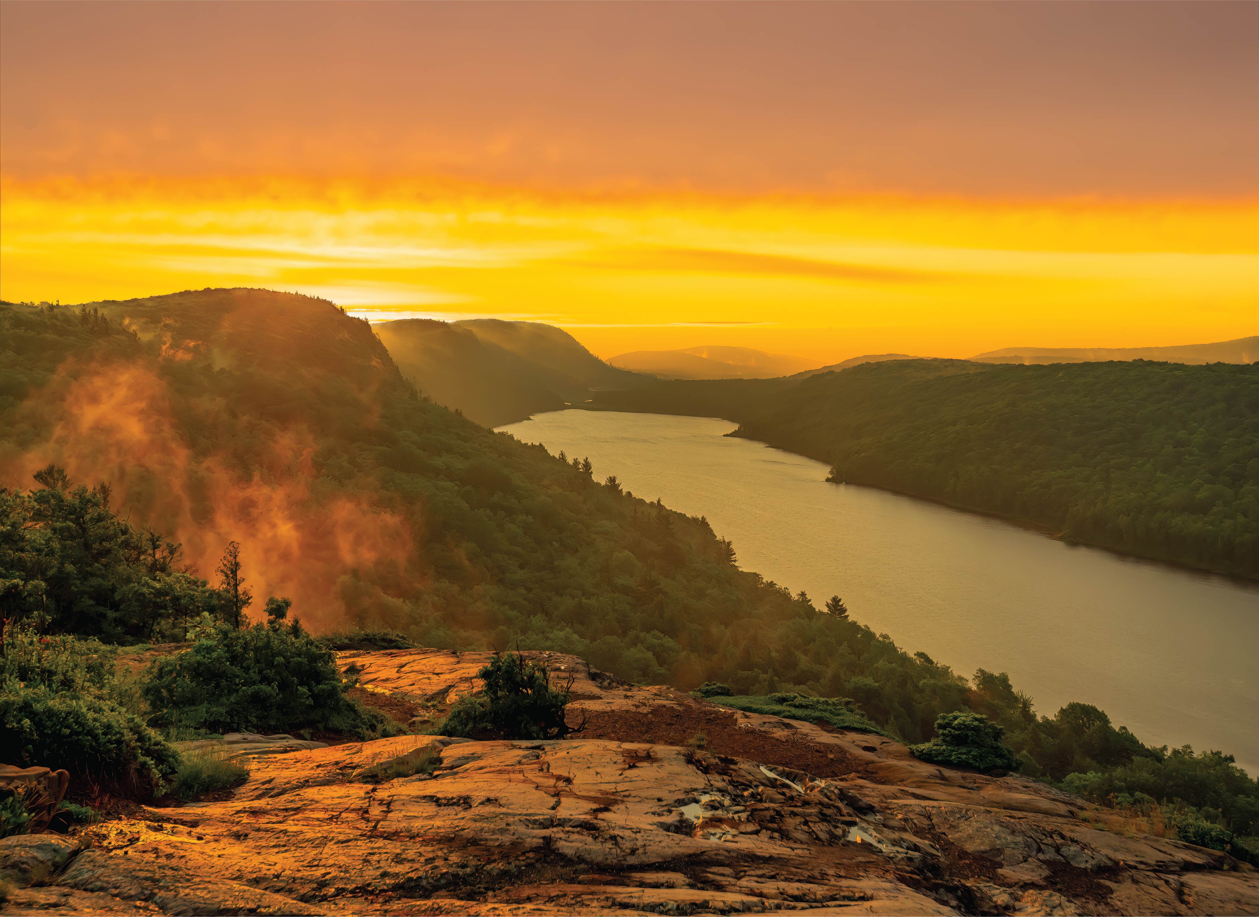 Image of Lake Superior with Golden Sky and Midst Rising from Tree-line 